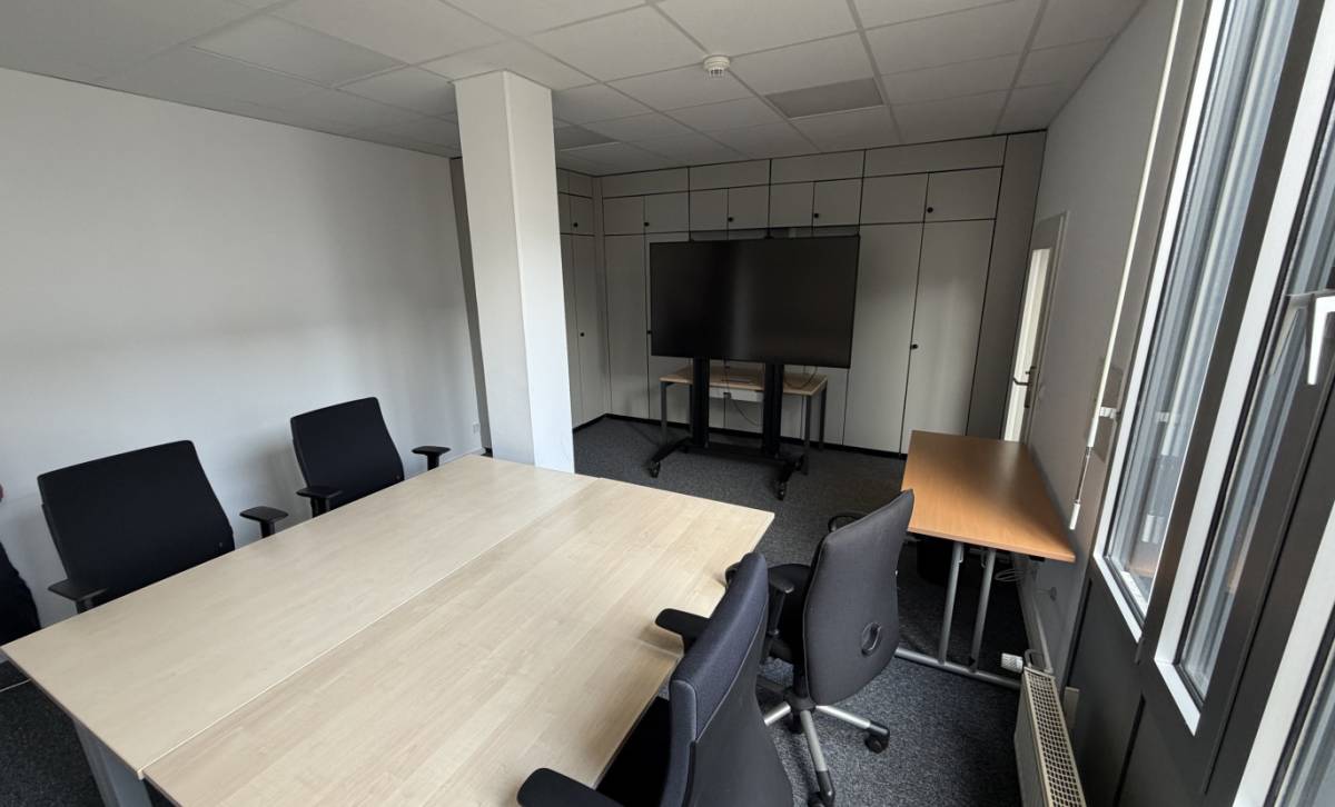 Büro mit Konferenztisch und Großbild-Monitor