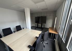 Büro mit Konferenztisch und Großbild-Monitor