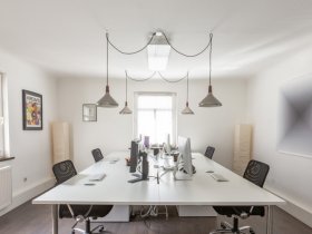 Einzelner, heller, moderner Büroabeitsplatz in kreativer Umgebung