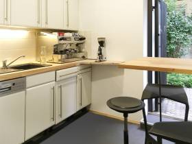 Schreibtische in großem Büroraum mit Gartenzugang