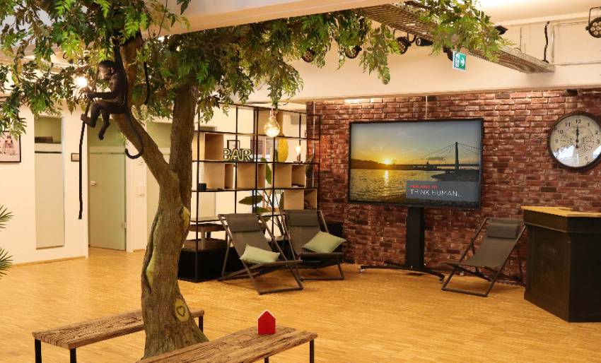 Zentraler Open Space mit allen Essentials wie Bar, Baum, TV und 