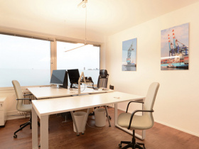 Schreibtischplätze in hellem Büro mit Blick über Hamburg
