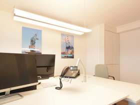 Schreibtischplätze in hellem Büro mit Blick über Hamburg